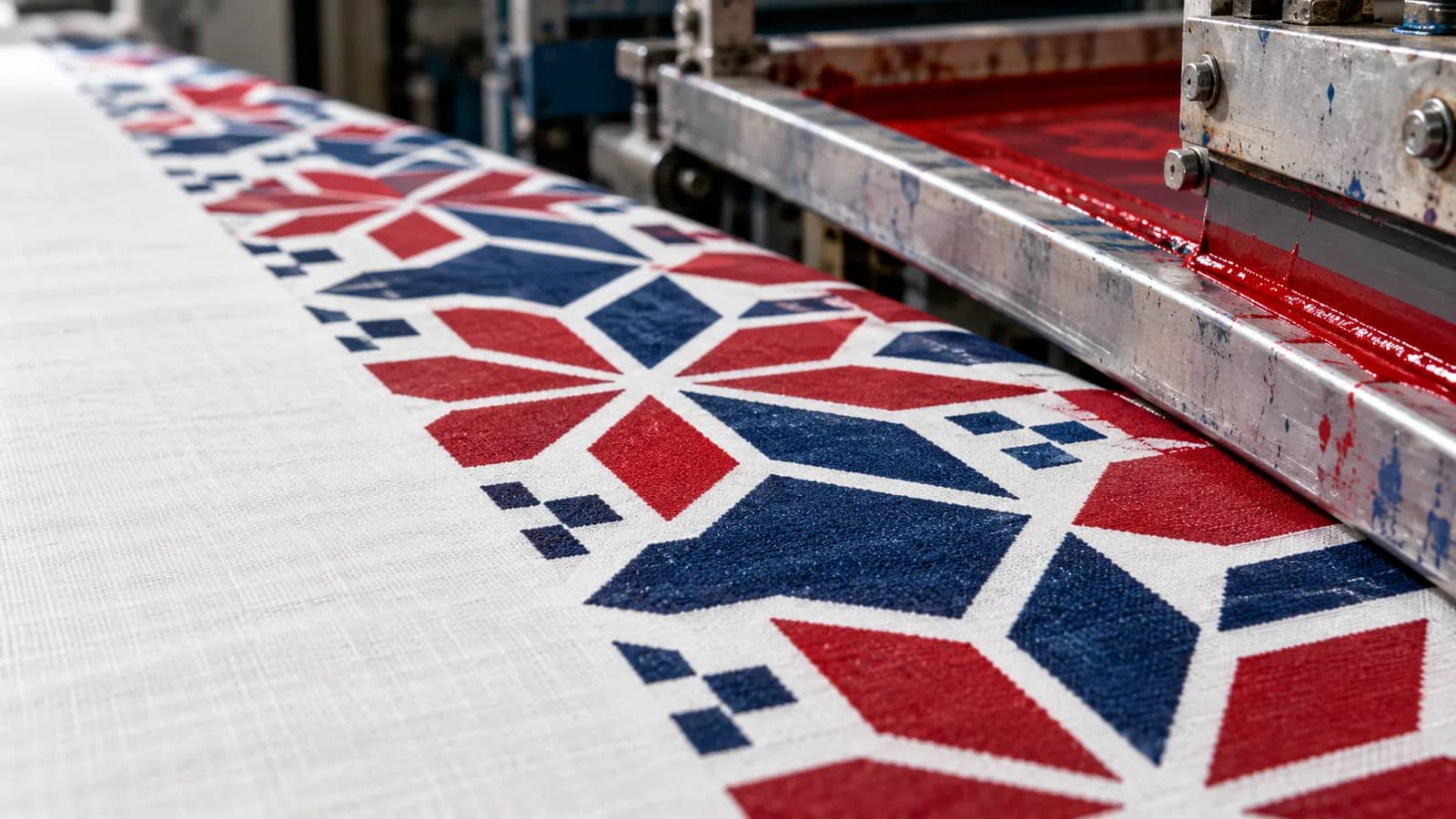 Illustration: crisp red and indigo pattern on cotton coming off a rotary screen printing machine